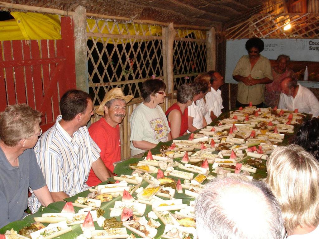 Sailors from around the world enjoy a Tongan feast. © Larry Macdonald